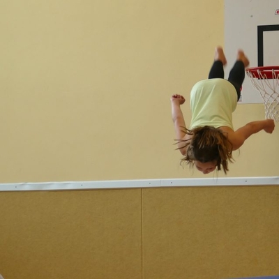 Als st&uuml;rzte sich eine Sch&uuml;lerin direkt aus dem Basketball-Korb ins Ungl&uuml;ck &ndash; so spektakul&auml;r verlief der Programmpunkt &bdquo;Turnfeuerwerk &ndash; Sportklasse and Friends&ldquo;, den die Klasse 5b vorbereitet hatte. (s. auch das Video am Ende des Artikels)